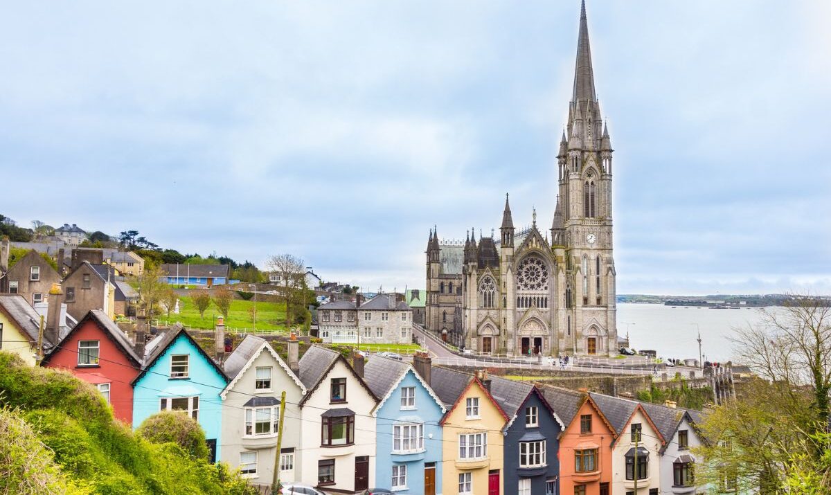 Cathedral and colored house in Cobh, Ireland investing in Ireland