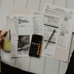 Stack of paper with someone doing their taxes. Arkansas Income Tax Rate article