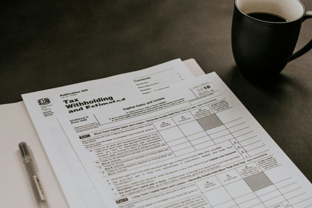 Tax forms in a file next to a mug of coffee. Nebraska Income Tax Rate