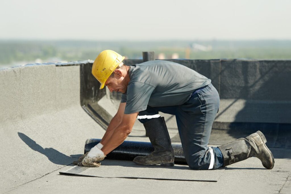 Worker applying flat roof. Who Owns B.R. Jones Roofing Co article