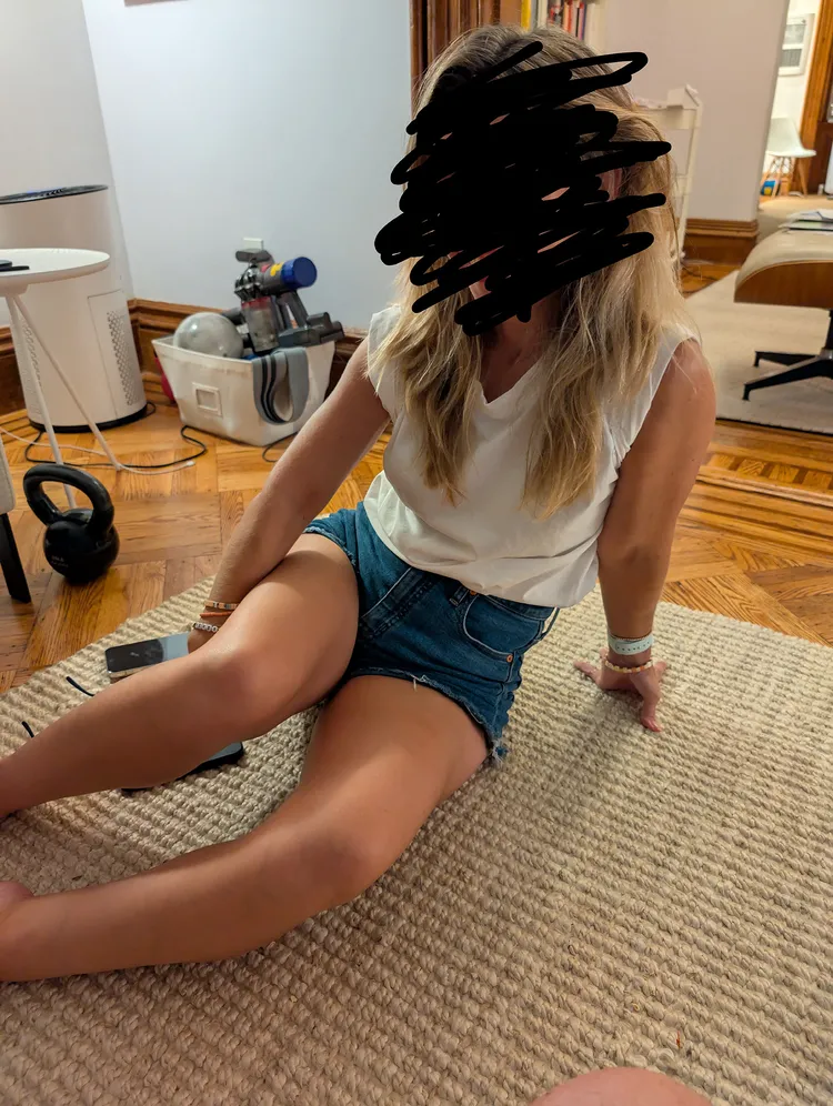 A real photo of a person in a living room (with their face obscured).