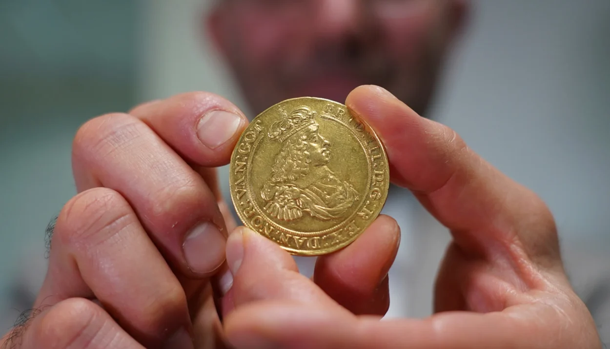 Vicken Yegparian the Vice President of Numismatics at Stacks Bowers Galleries holds a golden coin from the L E Bruun collection