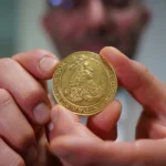 Vicken Yegparian the Vice President of Numismatics at Stacks Bowers Galleries holds a golden coin from the L E Bruun collection