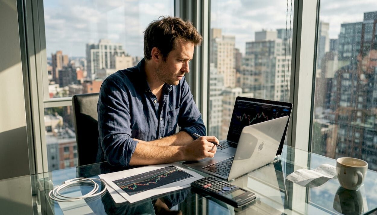 Man updating investment charts in sunlit office