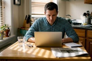 Investor reviews portfolio at sunlit kitchen table