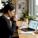Woman organizing finances at sunlit kitchen table