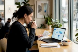 Woman organizing finances at sunlit kitchen table