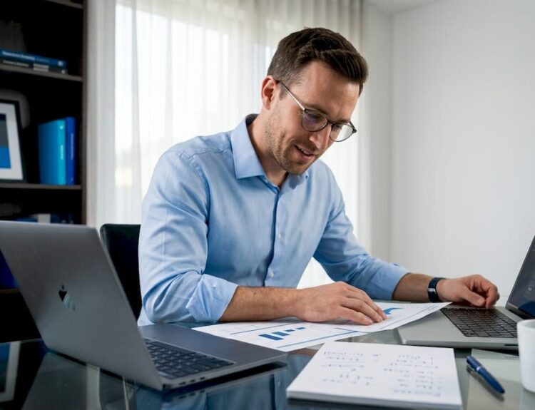 Business analyst reviewing report in sunlit home office