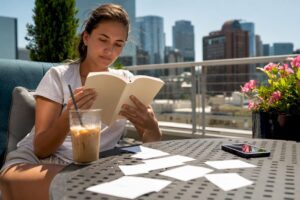 Young woman reading investing book at kitchen table