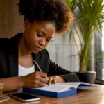 Woman writing goals in home office planner