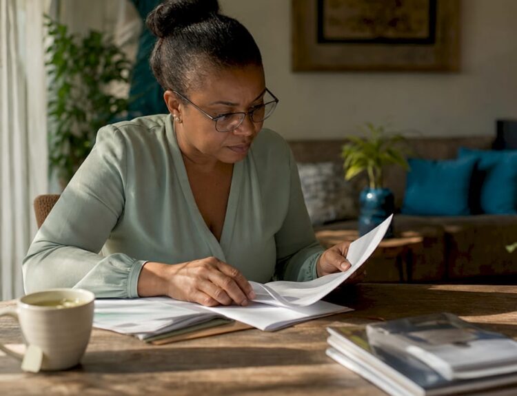 Woman reviewing passive income documents at kitchen table