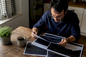 Investor studying printed stock market charts