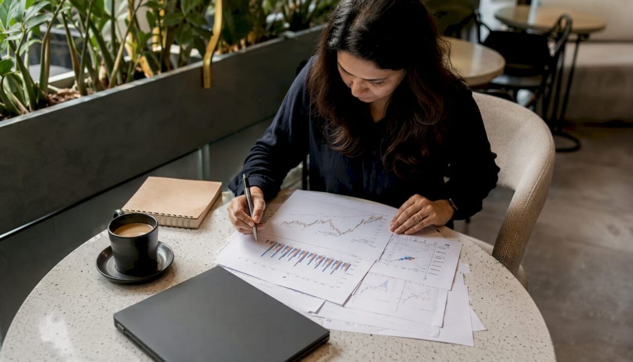Woman paper-trading stocks at home desk