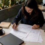 Woman paper-trading stocks at home desk