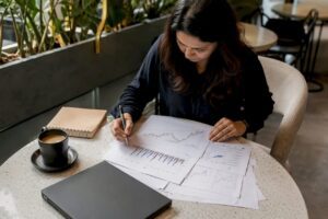 Woman paper-trading stocks at home desk