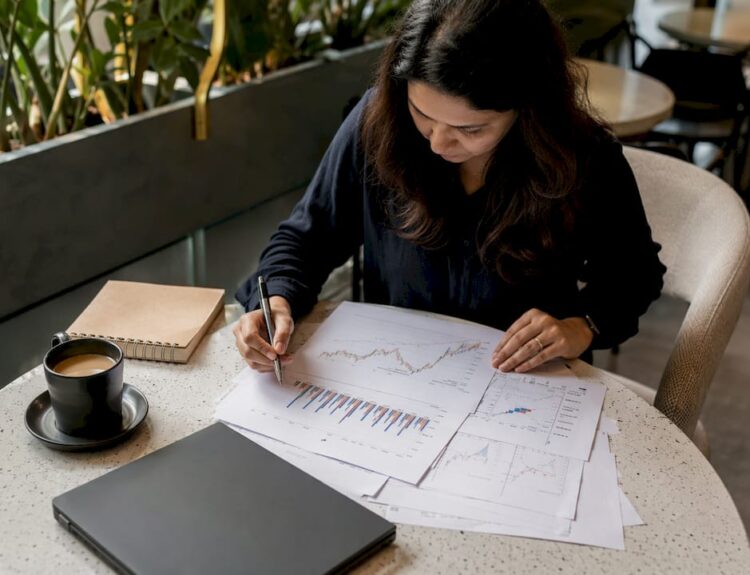 Woman paper-trading stocks at home desk