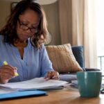 Woman reviewing IRA documents at home office table