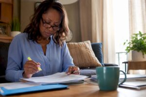 Woman reviewing IRA documents at home office table