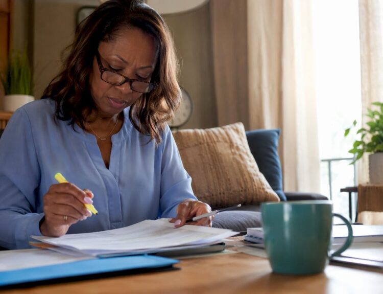 Woman reviewing IRA documents at home office table