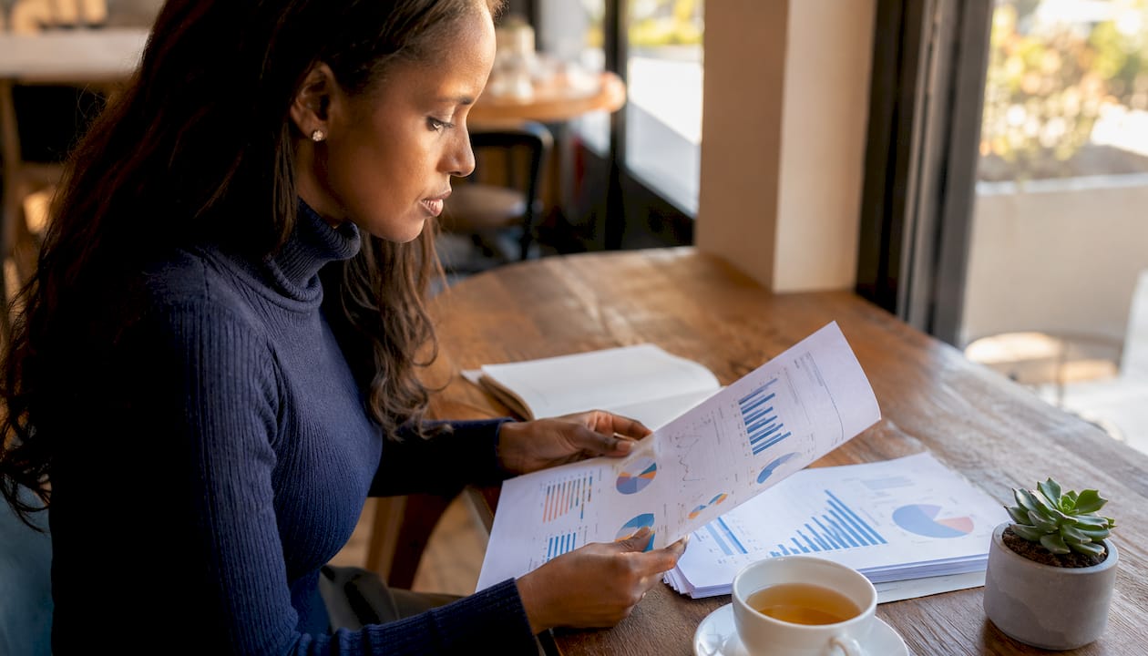 Investor reviewing currency exposure reports at desk