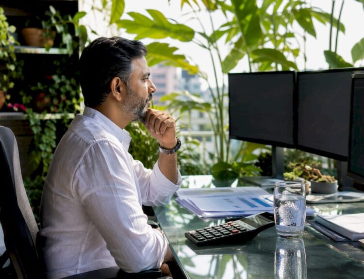 Trader monitoring currency exchange screens in office