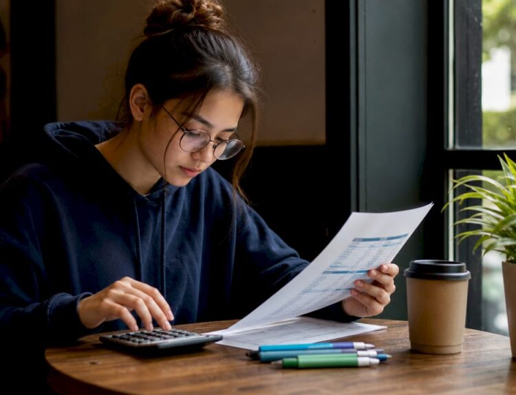 Student calculating personal budget at desk