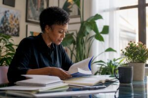 Woman reading investing books at home library desk