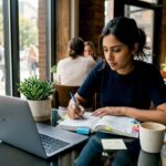 Woman studying stock market guide at home desk