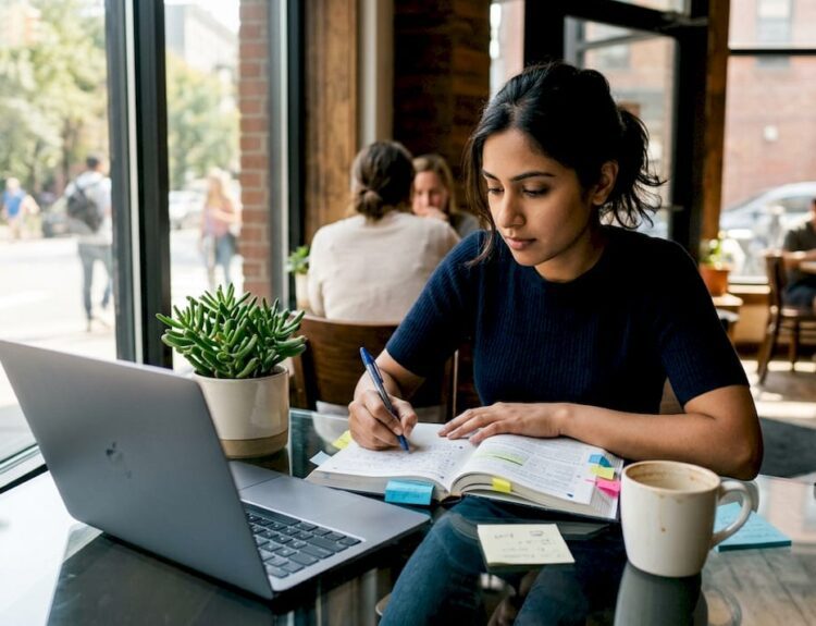 Woman studying stock market guide at home desk