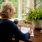 Woman preparing will documents at home desk
