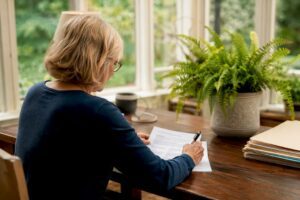 Woman preparing will documents at home desk