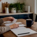 Hands arranging budgeting setup at home