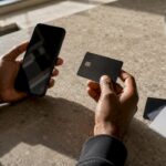Hands holding secured credit card and smartphone
