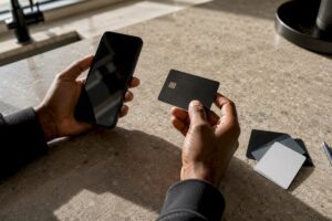 Hands holding secured credit card and smartphone