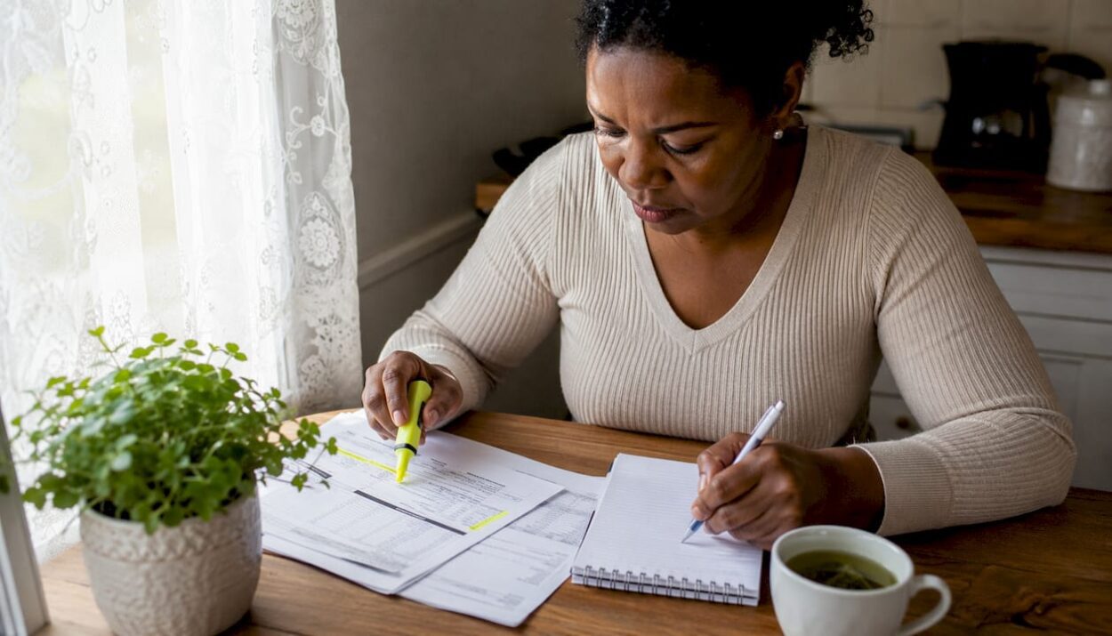 Woman reviewing financial documents at home desk