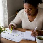 Woman reviewing financial documents at home desk