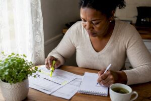 Woman reviewing financial documents at home desk