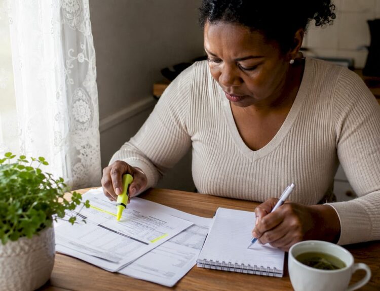 Woman reviewing financial documents at home desk