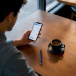 Adult logging a daily expense at café table